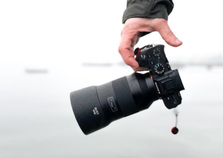 Fotograf geht mit Kamera durch eine urbane Umgebung